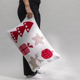 Valkoinen tyynynpäällinen, jossa värikkäitä jouluisia kuvia.